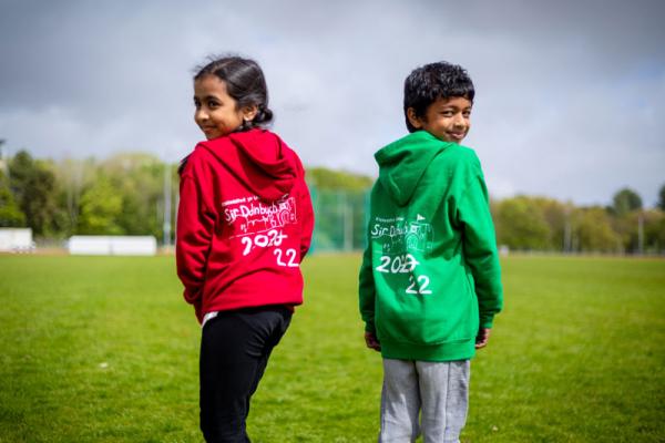 Dau blentyn yn gwisgo dillad yr Urdd.